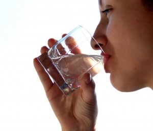 "woman drinking water to keep body hydrated"